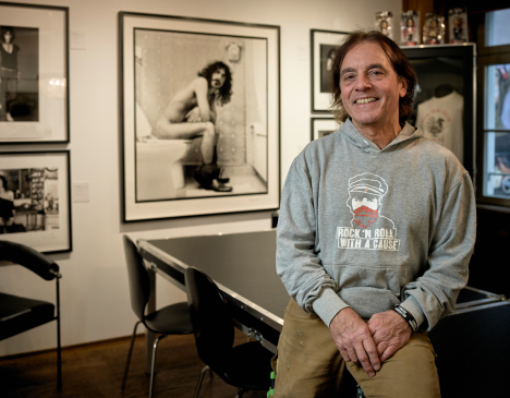 Andy Ibach in front of a photograph of Frank Zappa.